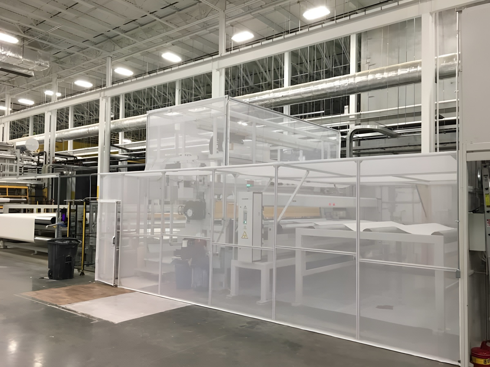 White mesh enclosure around production equipment in a warehouse